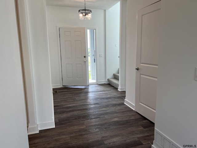 entrance foyer with a notable chandelier and dark hardwood / wood-style flooring