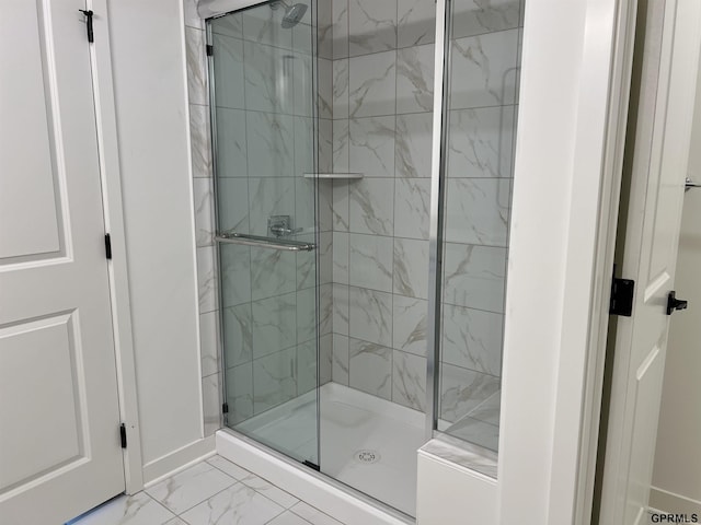 bathroom with baseboards, marble finish floor, and a shower stall