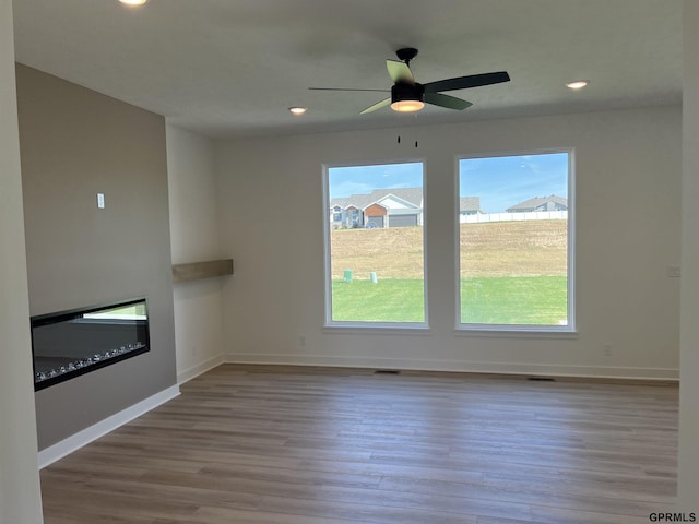 unfurnished living room featuring ceiling fan, light hardwood / wood-style flooring, and plenty of natural light