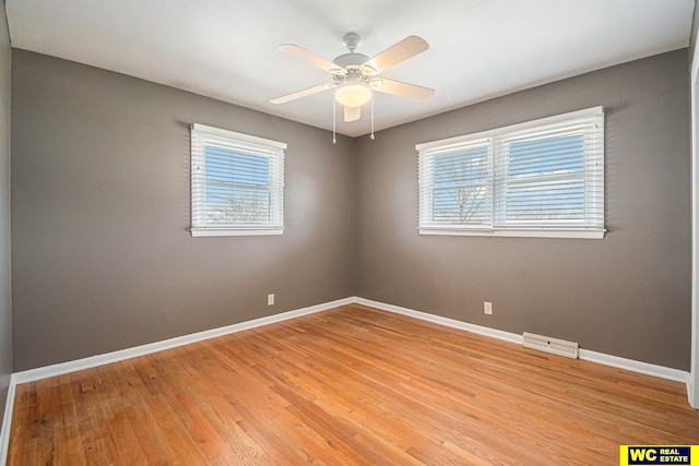 empty room with ceiling fan and light hardwood / wood-style flooring