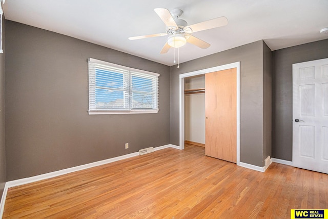 unfurnished bedroom with ceiling fan, a closet, and light wood-type flooring