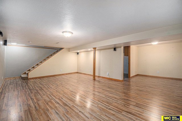 basement featuring hardwood / wood-style floors and a textured ceiling