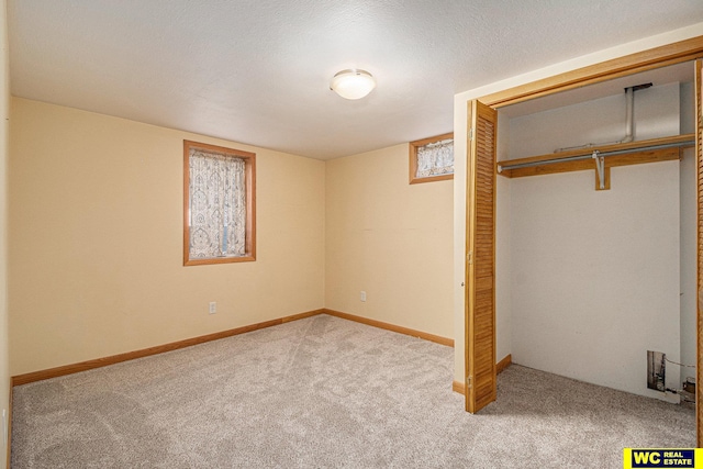 unfurnished bedroom with a closet, light colored carpet, and a textured ceiling