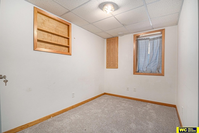 spare room featuring built in shelves and carpet floors