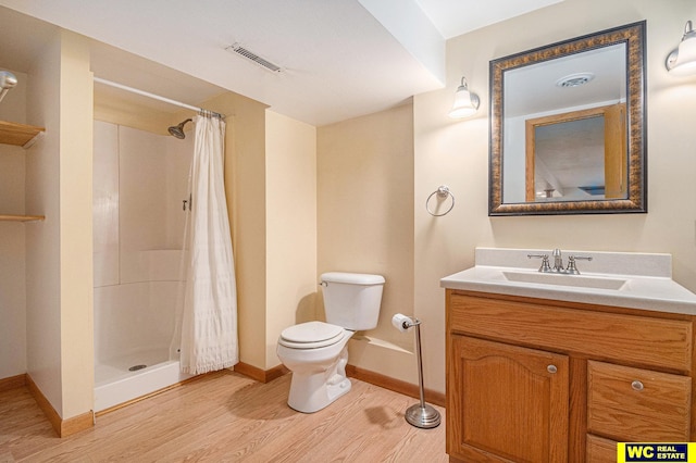 bathroom featuring hardwood / wood-style floors, vanity, toilet, and walk in shower