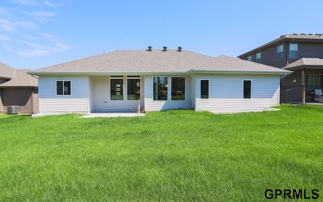 rear view of property with a patio, a yard, and central AC