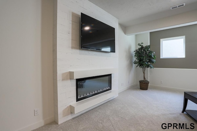 unfurnished living room with carpet floors and a textured ceiling