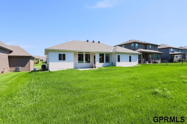 back of house with cooling unit and a lawn