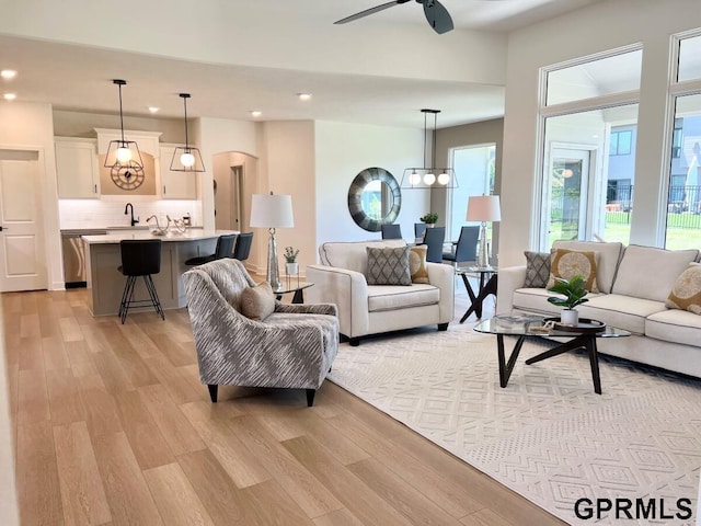 living room with ceiling fan and light wood-type flooring