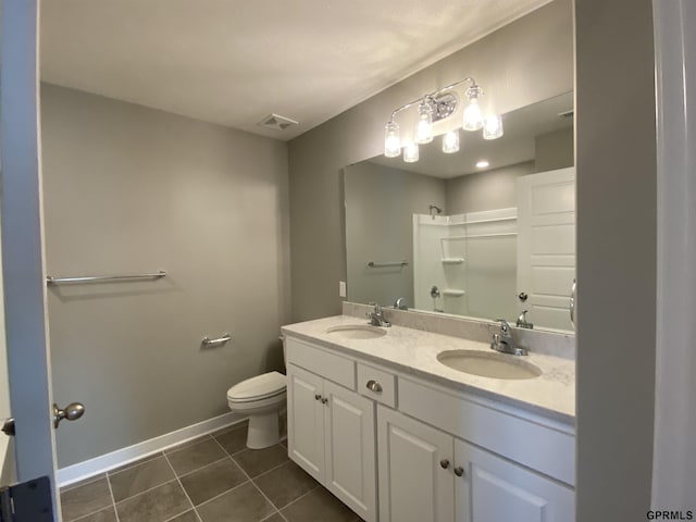 bathroom featuring tile patterned floors, a shower, vanity, and toilet