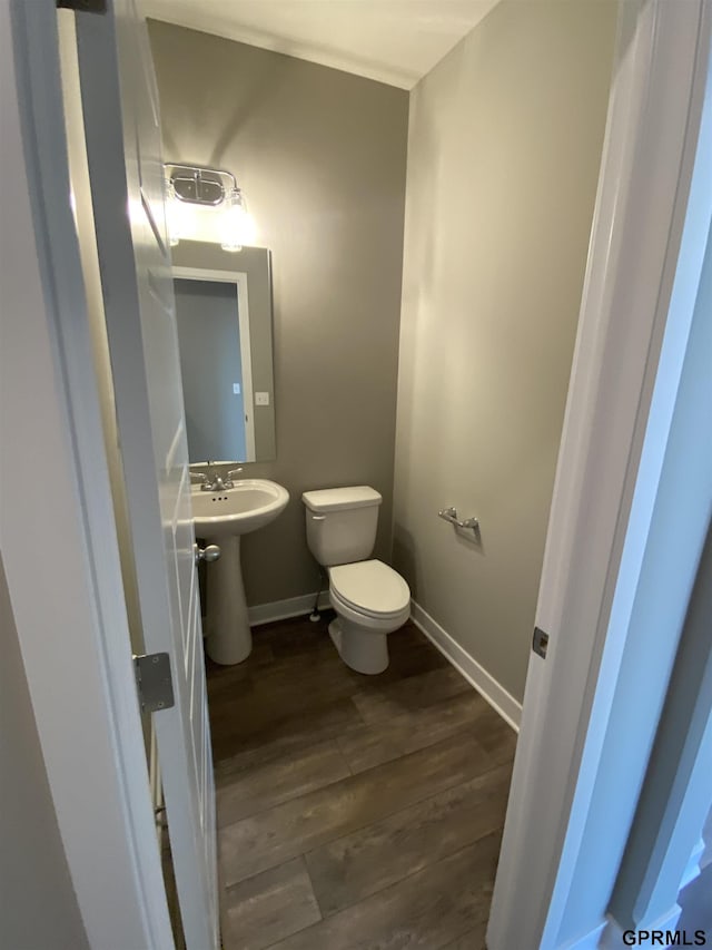 bathroom with hardwood / wood-style flooring, toilet, and sink