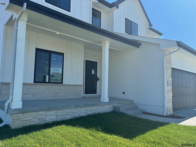 doorway to property with a porch and a garage