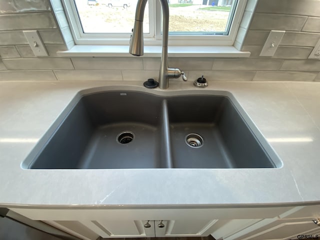 room details featuring decorative backsplash and sink