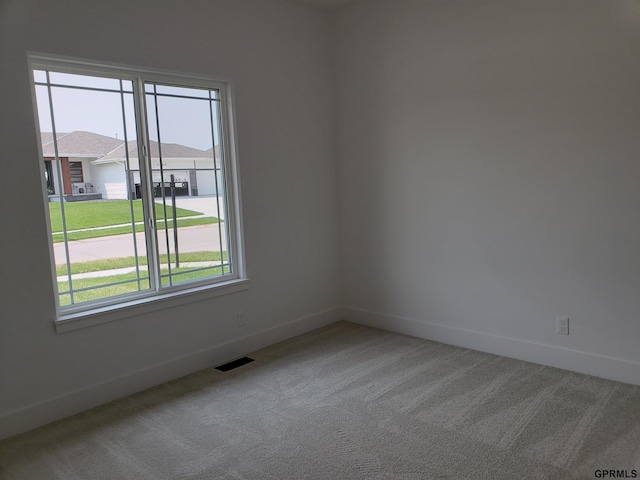 carpeted spare room featuring plenty of natural light