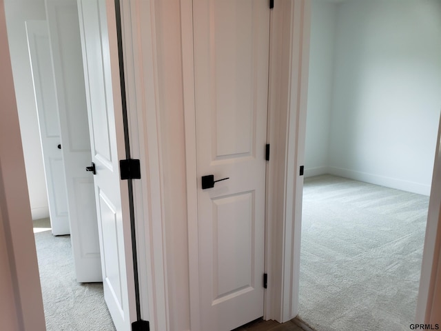 hall featuring light colored carpet