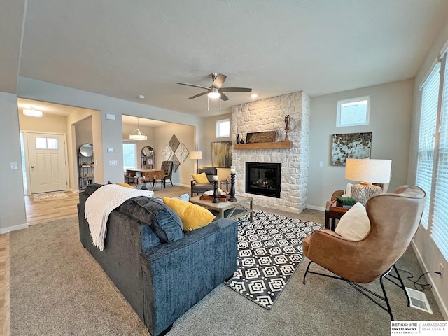 living room with ceiling fan, a fireplace, and light colored carpet