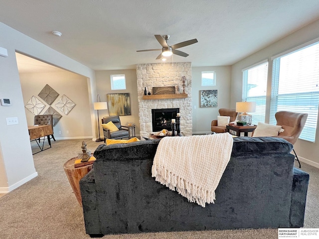 carpeted living room with a fireplace and ceiling fan