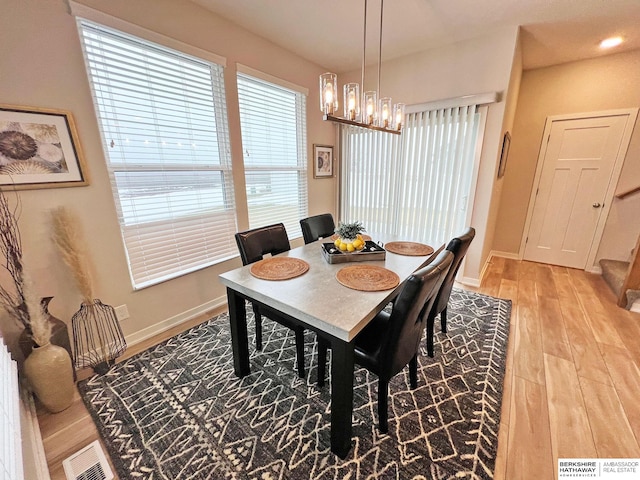 dining area featuring a notable chandelier and light hardwood / wood-style floors