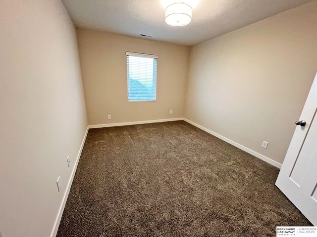 unfurnished room with dark carpet