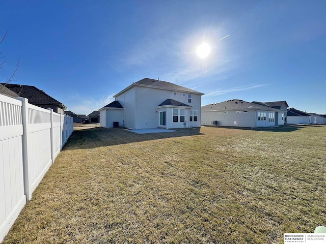 back of house with a lawn and a patio area