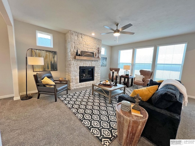 carpeted living room featuring ceiling fan and a fireplace