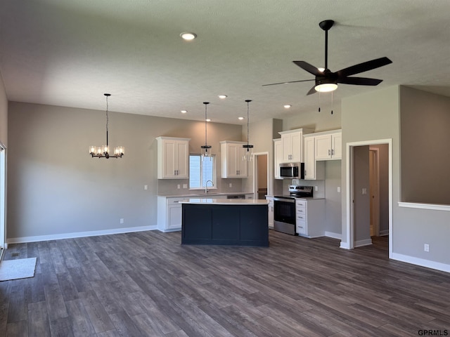 kitchen with white cabinets, decorative light fixtures, a kitchen island, and appliances with stainless steel finishes