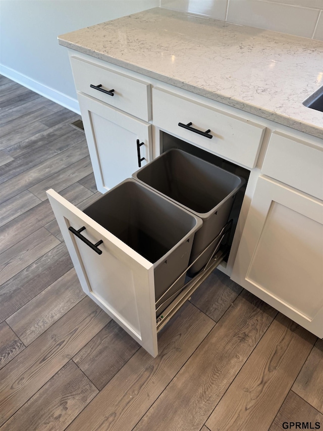 details with white cabinets, dark hardwood / wood-style floors, and light stone counters