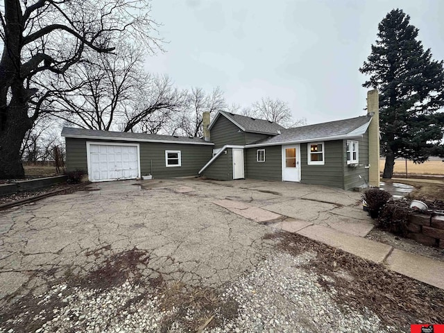 rear view of property featuring a garage