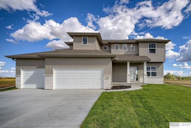 prairie-style home featuring a garage and a front lawn