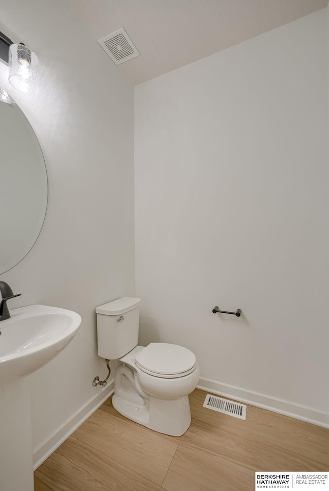 bathroom with hardwood / wood-style floors, toilet, and sink