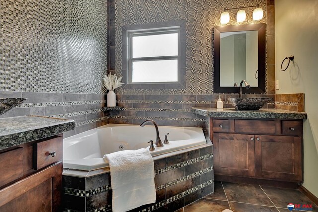 bathroom with vanity, a relaxing tiled tub, and tile patterned floors