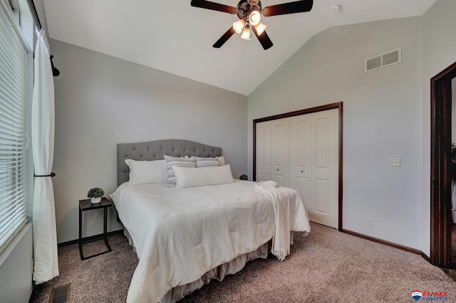 carpeted bedroom featuring a closet, vaulted ceiling, and ceiling fan