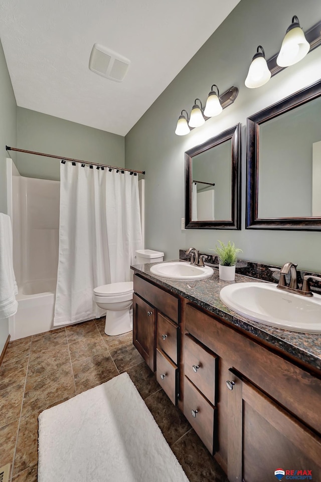 full bathroom featuring vanity, shower / bath combination with curtain, and toilet