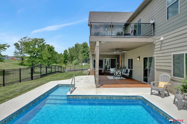 view of pool featuring ceiling fan, a patio area, and a lawn