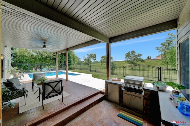 view of patio / terrace featuring a fenced in pool, an outdoor kitchen, ceiling fan, a grill, and a rural view