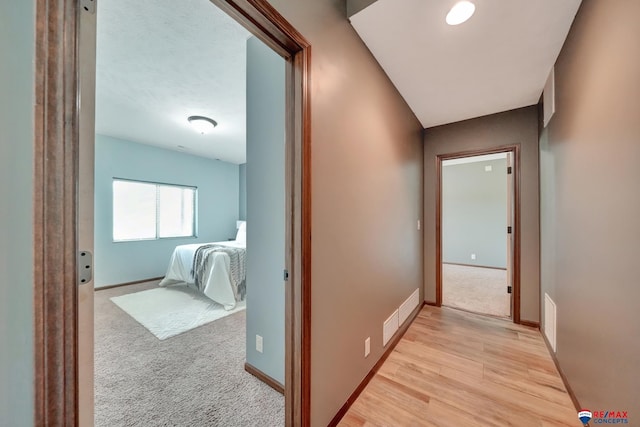 hallway with light hardwood / wood-style flooring