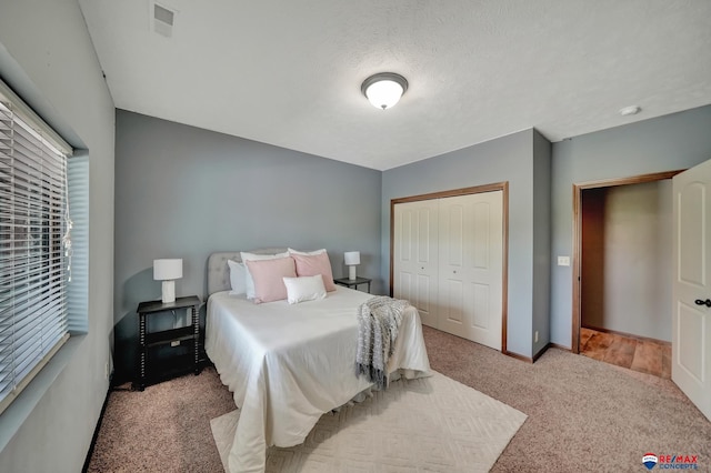 carpeted bedroom featuring a closet and a textured ceiling