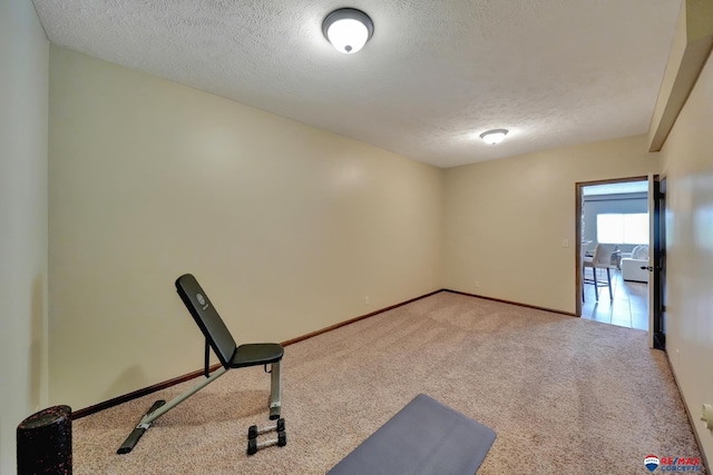 workout area with carpet flooring and a textured ceiling