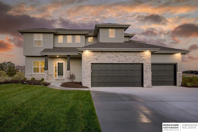 prairie-style home with a garage and a yard