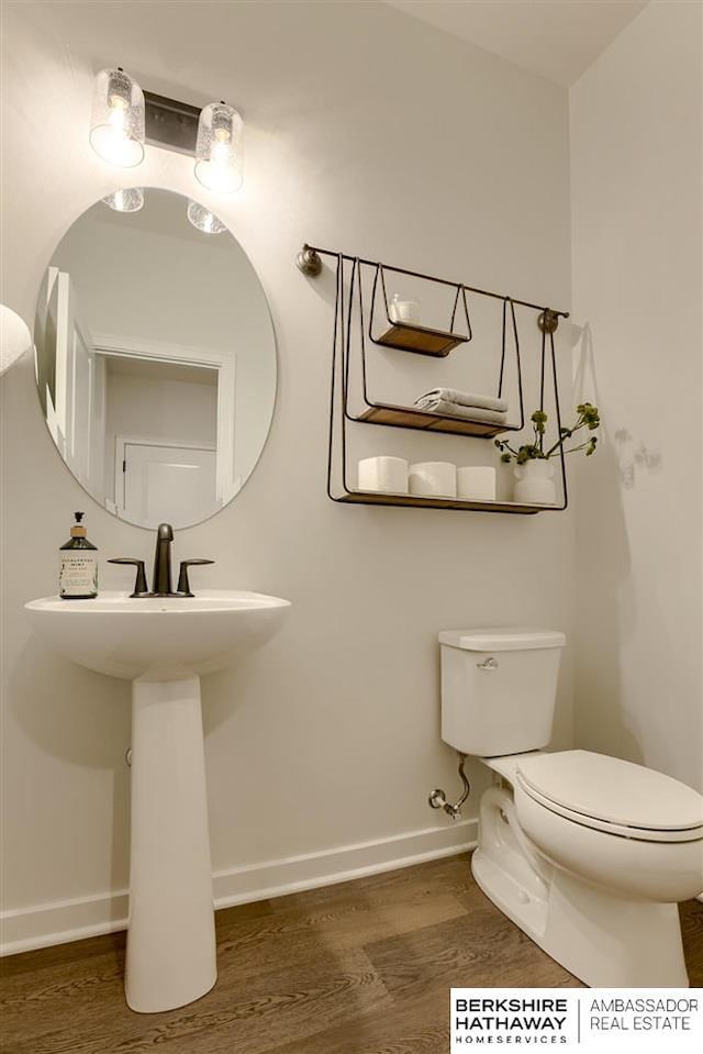 bathroom with hardwood / wood-style floors and toilet