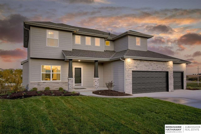 prairie-style home with a lawn and a garage