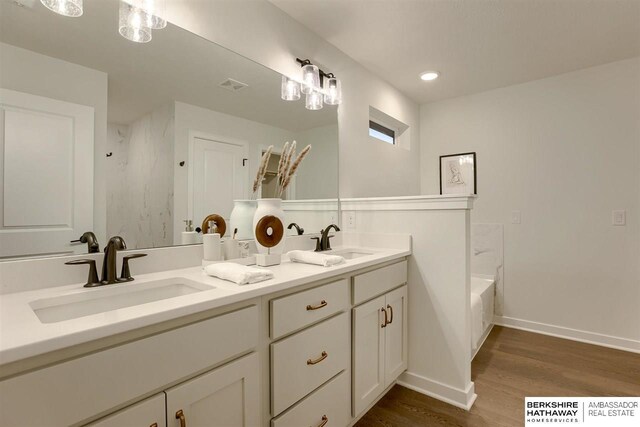 bathroom featuring vanity, wood-type flooring, and shower / washtub combination