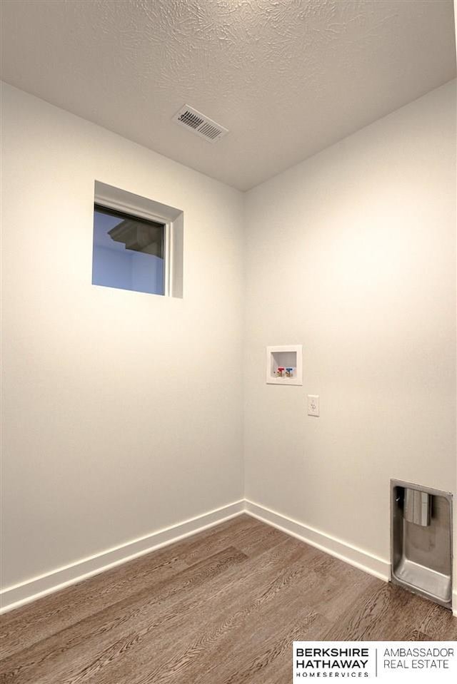 laundry room with a textured ceiling, washer hookup, and dark hardwood / wood-style floors