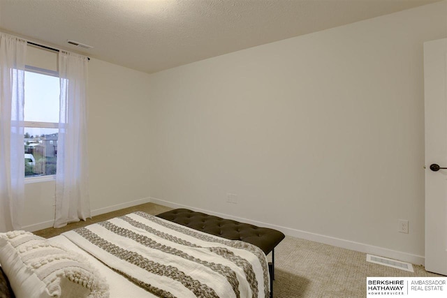 carpeted bedroom featuring a textured ceiling