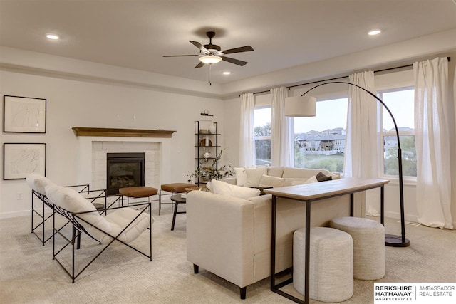 living room with ceiling fan, a fireplace, and light carpet