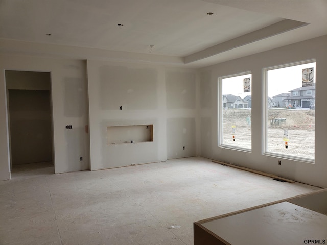 unfurnished living room featuring a tray ceiling