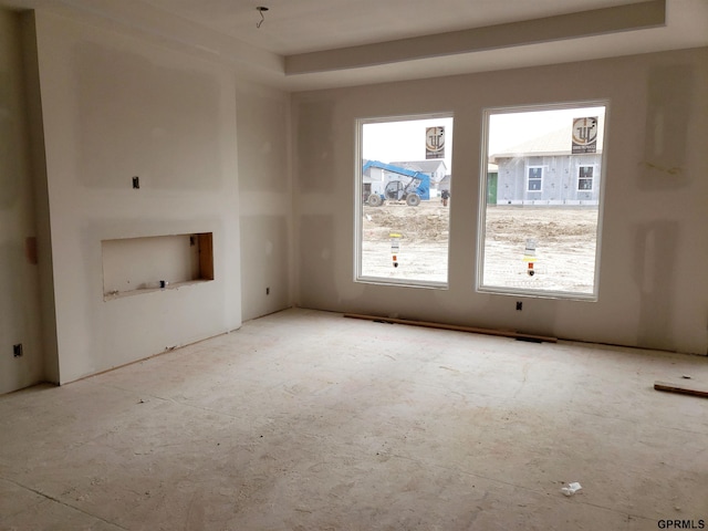 unfurnished living room with a tray ceiling