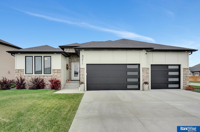 prairie-style house featuring a garage and a front lawn