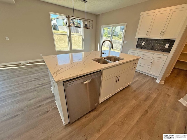 kitchen with white cabinets, sink, hanging light fixtures, stainless steel dishwasher, and light stone countertops