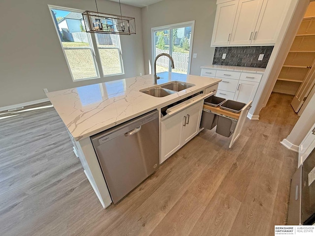 kitchen with dishwasher, light stone counters, and white cabinetry